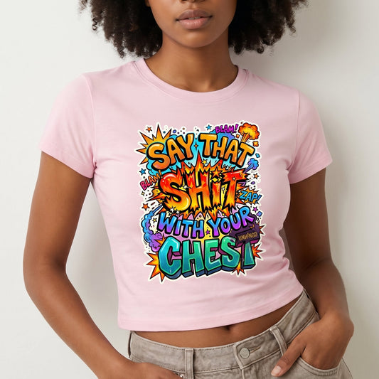 Person wearing a pink t-shirt with colorful text design on a plain background